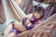 A woman in a purple bikini laying in a hammock.