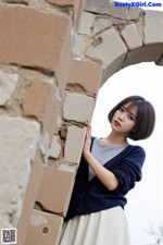 三菱爱 - 云鬓花颜映水清 Set.1 20241116 Part 4 A woman leaning against a stone wall with her hand on her hip.