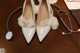 A pair of white wedding shoes and a stethoscope on a table.