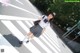 A woman in a school uniform is standing on a crosswalk.