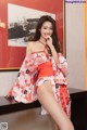 A woman in a red and white kimono posing for the camera.